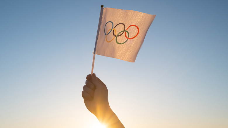 Person holding flag with Olympic rings