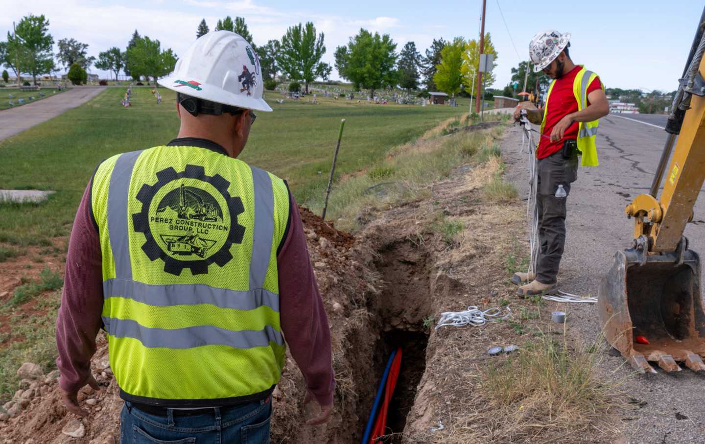 Workers digging a hole to install a cable