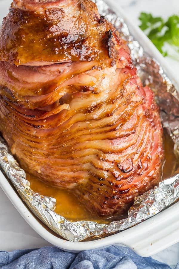 whole spiral ham in baking dish with honey glaze