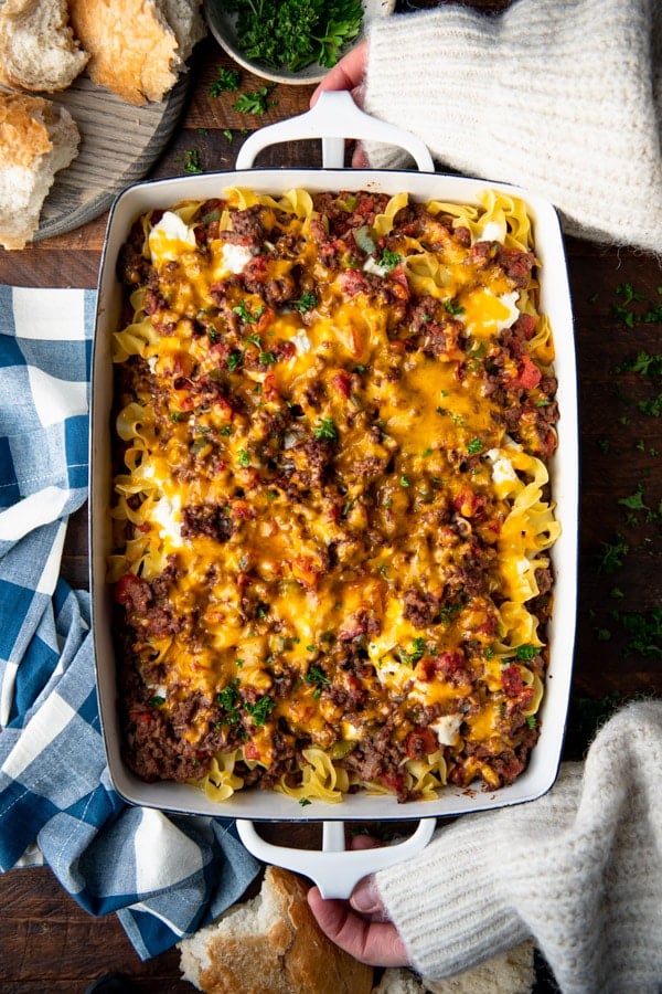 Pan of hamburger noodle casserole on a wooden table.