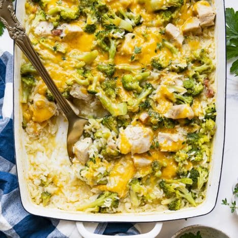 Square overhead shot of easy chicken broccoli rice casserole on a white table.