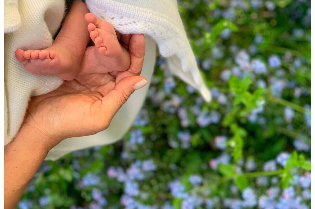 Meghan holding the feet of her first baby, Archie Harrison Mountbatten-Windsor to mark her first Mother's Day in 2019