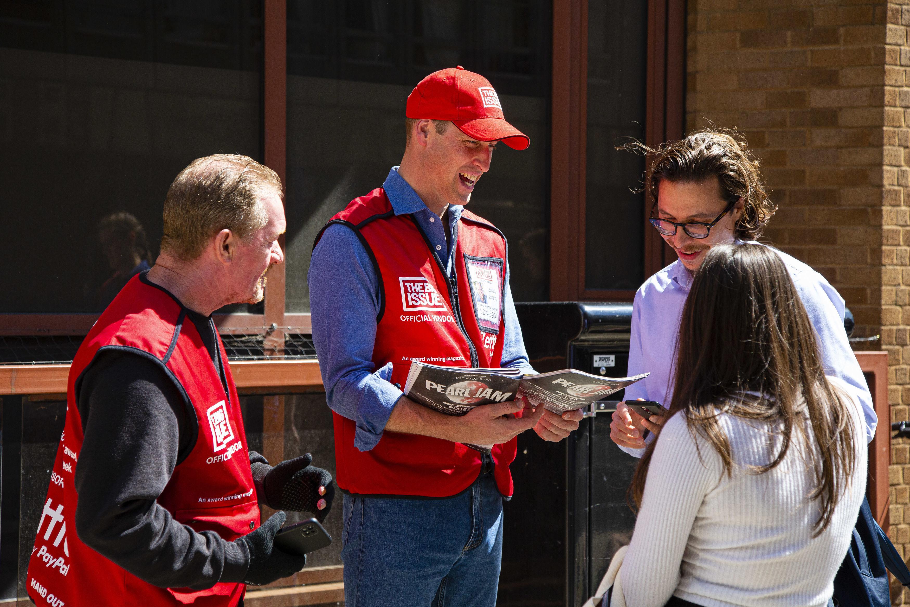 In 2022, William sold copies of the Big Issue, with vendor Dave Martin, left, to passers-by in London