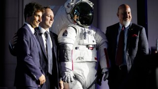 Axiom Space president Matt Ondler, right, Prada group chief marketing officer Lorenzo Bertelli, left, and Axiom executive vice-president Russell Ralstom with the suit in Milan