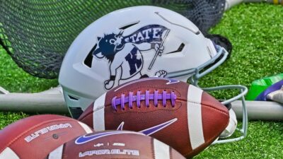 Kansas State Wildcats helmet and footbals on ground