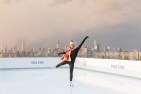 girl ice skating with NYC skyline in distance