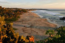 The sun sets over a deserted Playa Zicatela, as waves from the Pacific Ocean come crashing in, Puerto Escondido, Oaxaca, Mexico