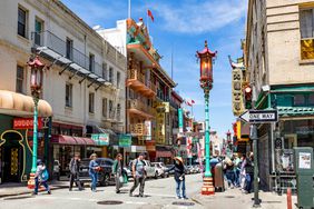 People walk across the street in Chinatown of San Francisco, California