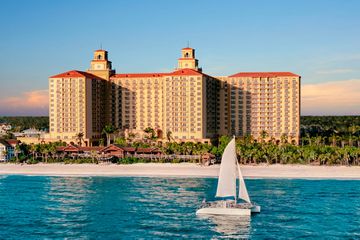 Exterior view of The Ritz-Carlton Naples with the ocean and beach in the foreground as a boat sails by