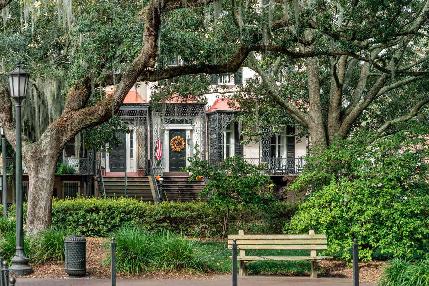 Lush green plants cover historic homes in Park Plaza in Savannah, GA