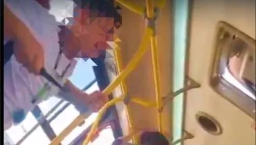 Imagem mostra um print do vídeo de uma briga dentro de um Ônibus de Curitiba.