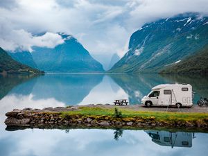 An RV parked lakeside in the Italian Alps