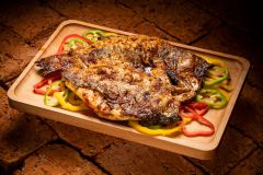 Whole grilled fish, butterflied, on a bed of sliced bellpeppers