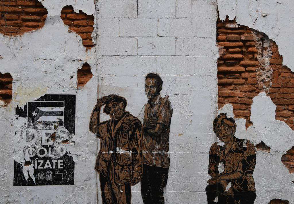 A mural of national heroes is seen outside a dilapidated building on May 8, 2017 in San Juan, Puerto Rico