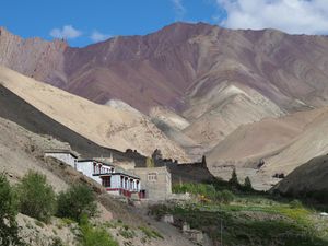 brown and pink mountains with a white building and grass