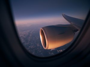 View From Window Of Airplane During Night Flight Above Ocean. Selective Focus On Jet Engine.