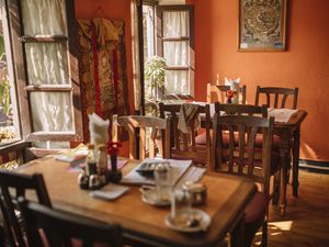 restaurant interior with wooden tables and chairs and open windows with sunlight