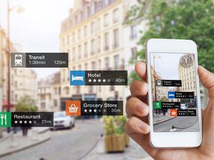 Augmented Reality (AR) information technology about nearby businesses and services on smartphone screen guide customer or tourist in the city, close-up of hand holding mobile phone, blurred street