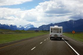 an RV driving on a highway toward mountains