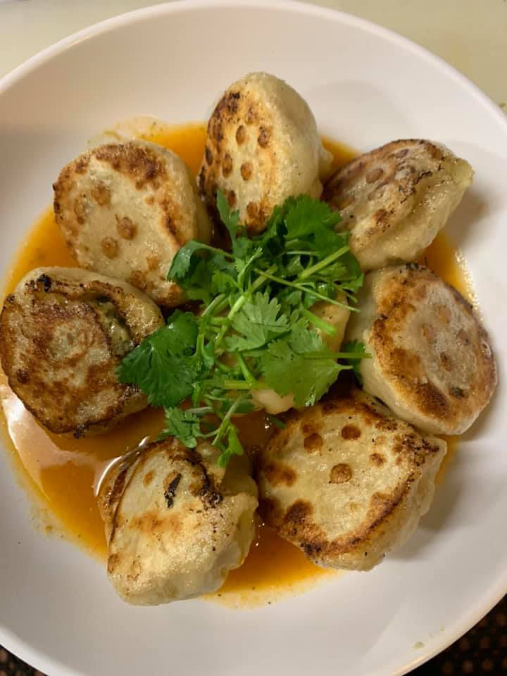 8 friend dumpling in a sauce, garnished with cilantro