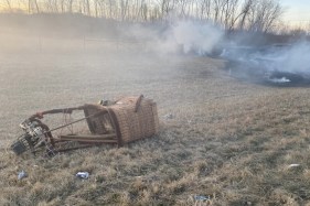 The remains of a hot air balloon rest on the ground.