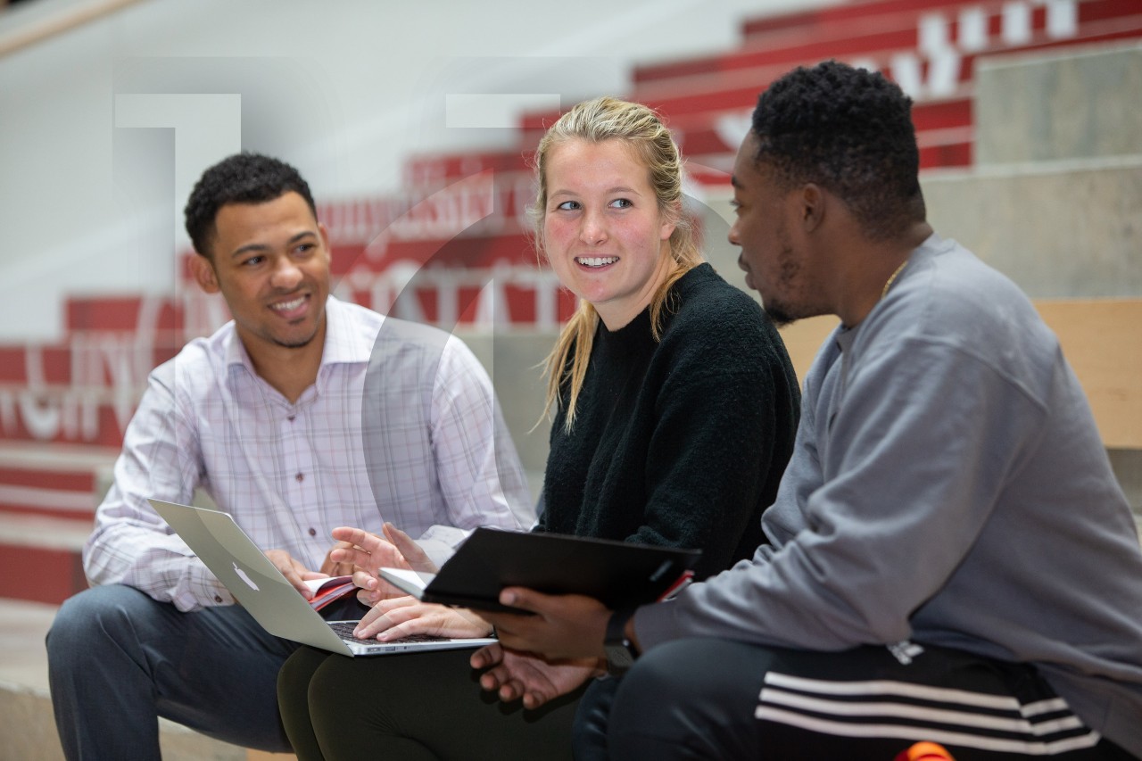 University of Cincinnati students converse on the steps in Lindner Hall