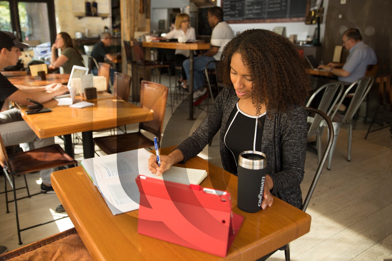 A UC students studies in a coffee shop