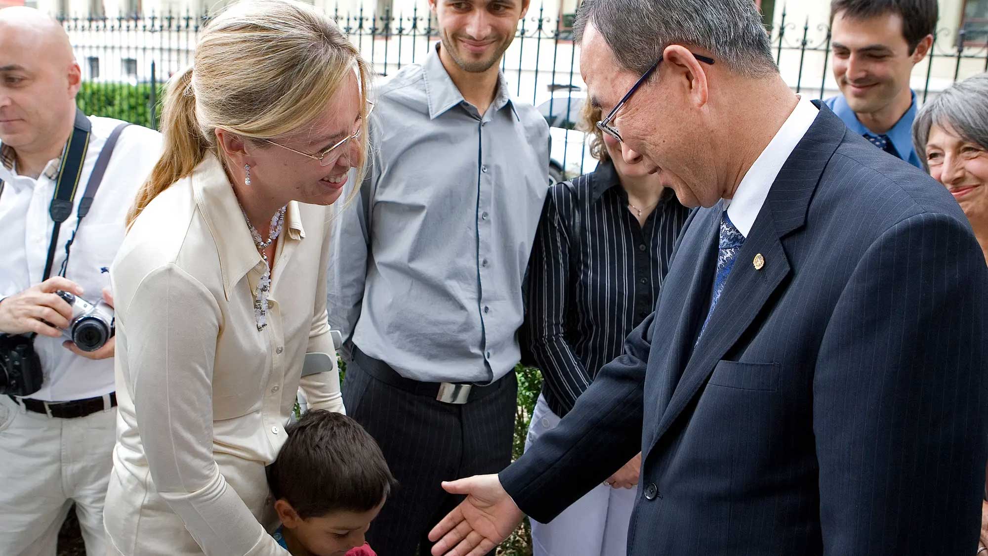 Ban Ki-moon meets with Laura Dolci and her son Mattias-Salim, while a group of people look on