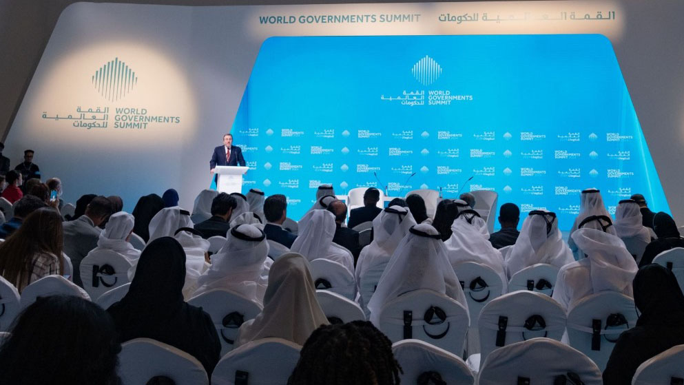 Achim speaks at a very large conference hall with many attendees in traditional clothes from the gulf region