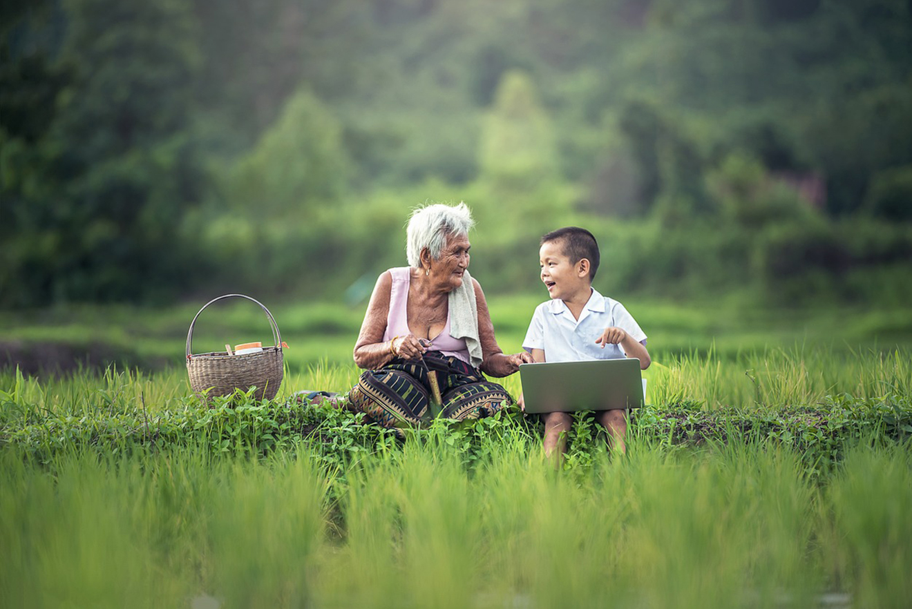 Elderly woman with a young boy interact with a computer