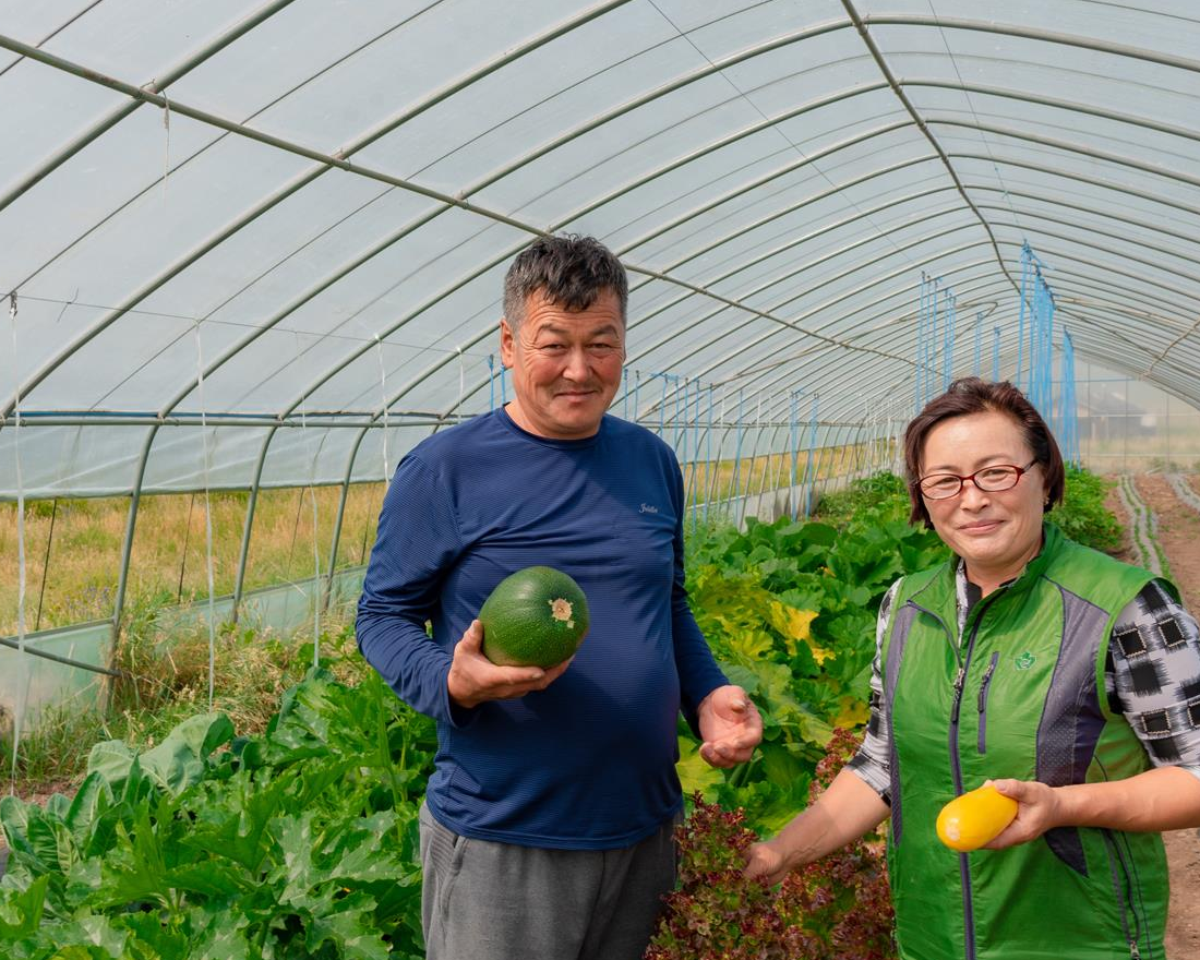 Female and male farmers showing their harvest