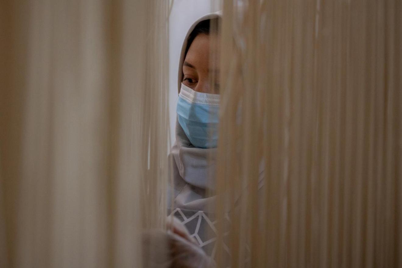 Woman's face behind freshly made noodles.