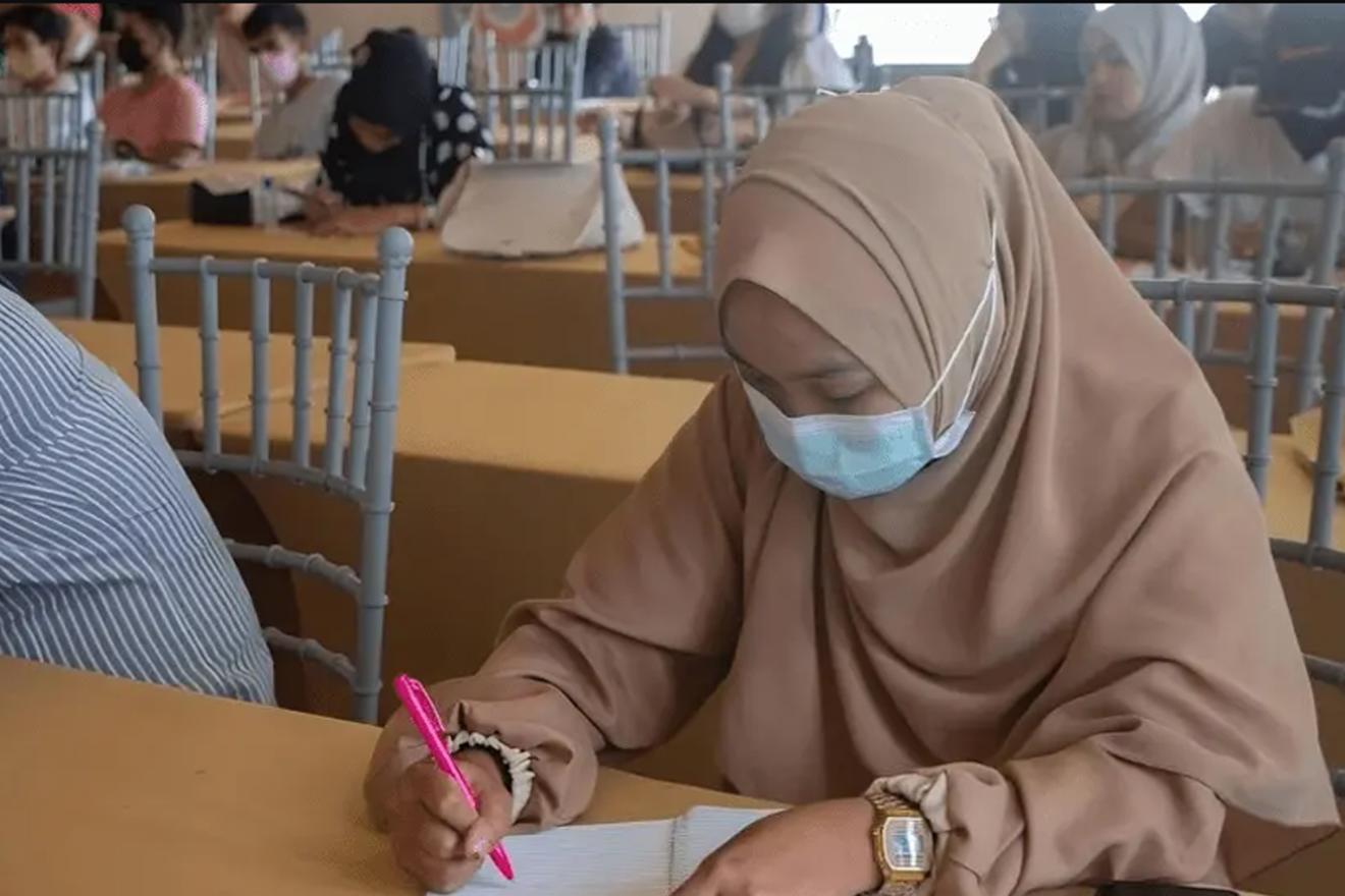 A woman making notes in her notebook. She raises awareness in her community about gender-based violence and harmful practices.