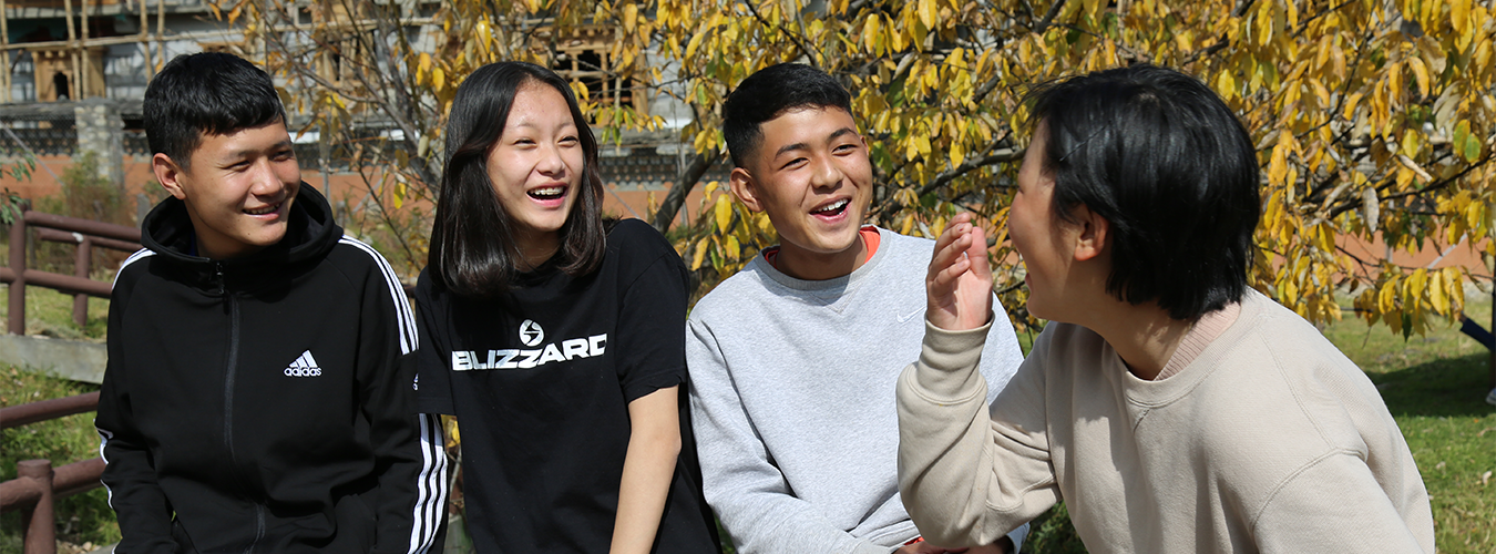 School friends spend some time together laughing at a park.