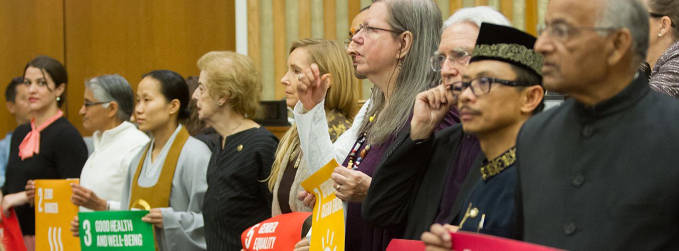 people holding hands at an event on Interfaith harmony