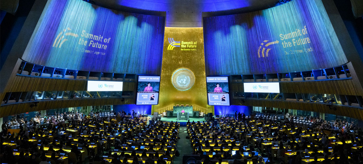 UN General Assembly hall wide view shown as is it lit up with the colors and logo of the Summit of the Future