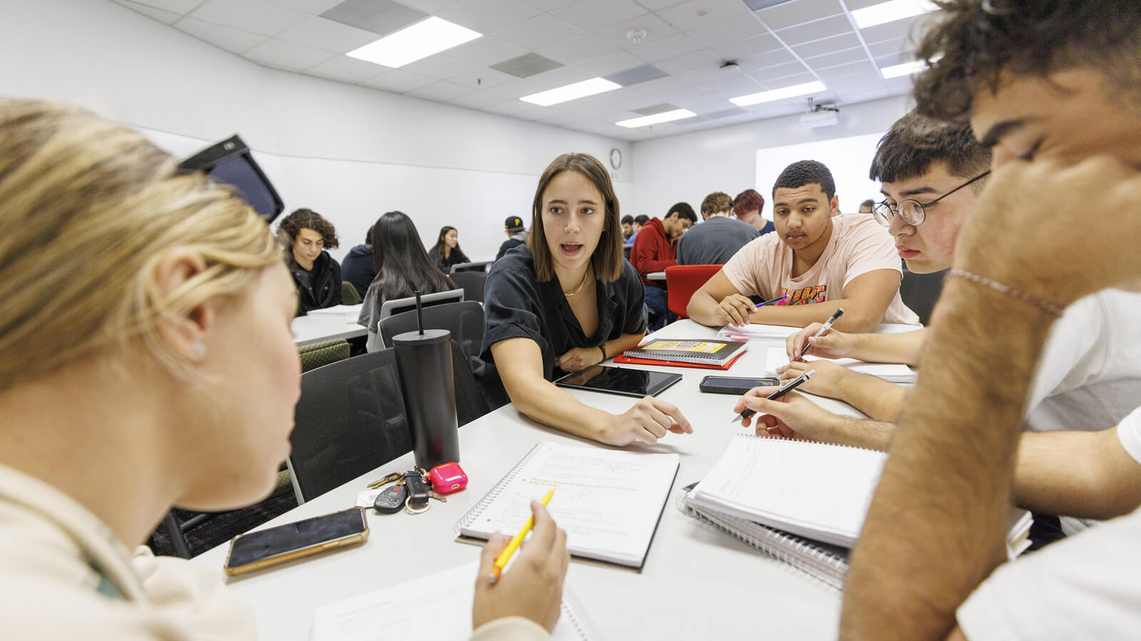 Professor discussing work with students in classroom