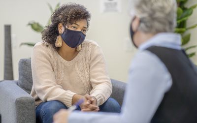 Patient and counsellor wearing face masks during a therapy session during the COVID-19 pandemic.