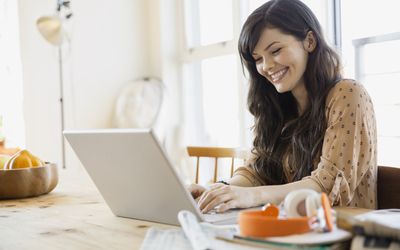 Woman on computer in kitchen