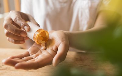 Hands of woman pouring prescription medicine in hand