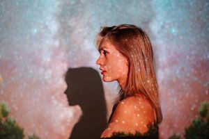 Blond young woman with starry sky projection