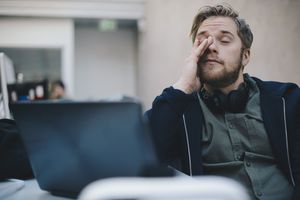 Fatigued man rubbing his eyes