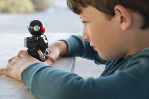 young boy holds robot 