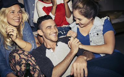 Man at a party with women around him