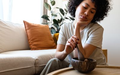 Young woman eating breakfast feeling very bored and unmotivated