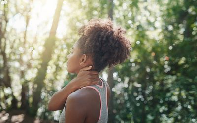 Woman rubbing her neck to ease body tension