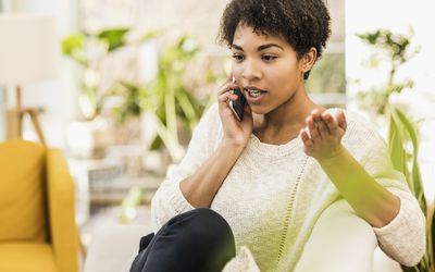 Woman talking on the phone while sitting at home