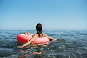 woman sitting in an inner tube in the ocean