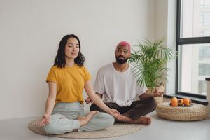 The guy doesn't really want to meditate and looks at his girlfriend with the thought that it' time to finish