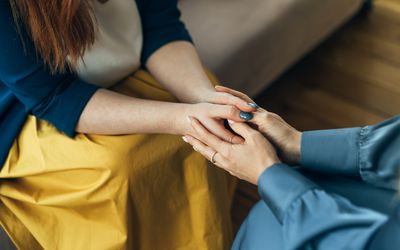 two people sitting in chairs holding hands